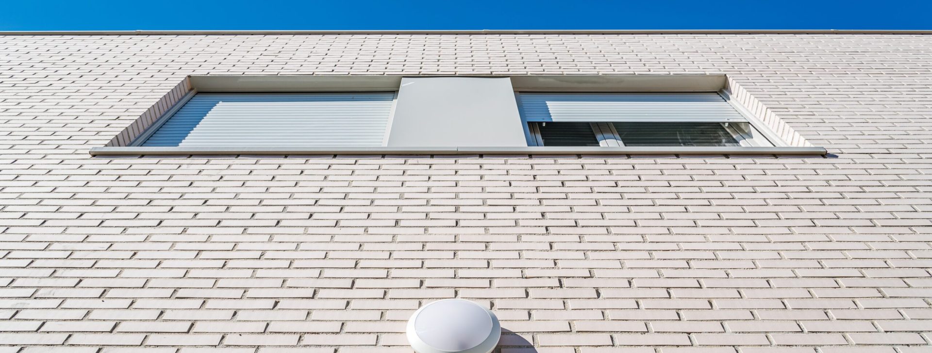 Modern row houses with brick facade. Low angle view against sky